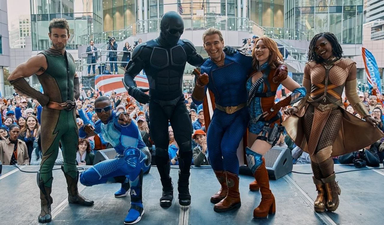 Cast members of The Boys Season 4 in superhero costumes posing at a public event.